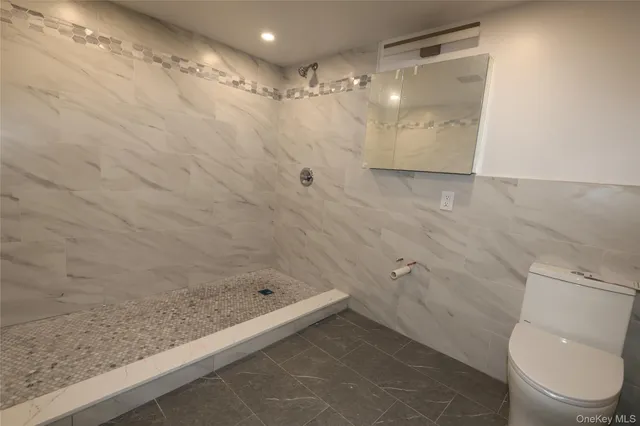 a bathroom with a granite countertop sink a toilet and shower