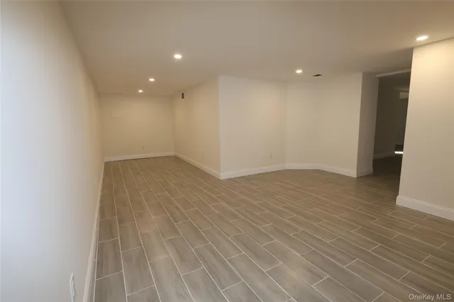 an empty room with wooden floor and entrance