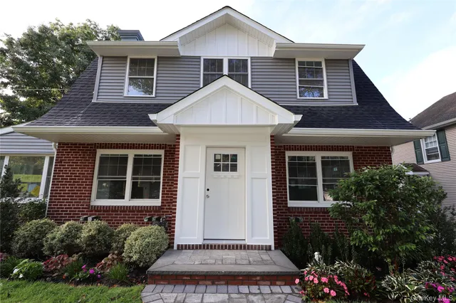 a front view of a house with a garden
