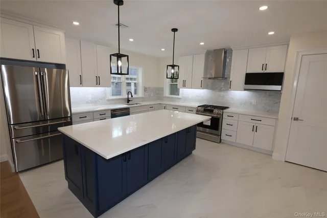 a kitchen with kitchen island a sink stainless steel appliances and cabinets