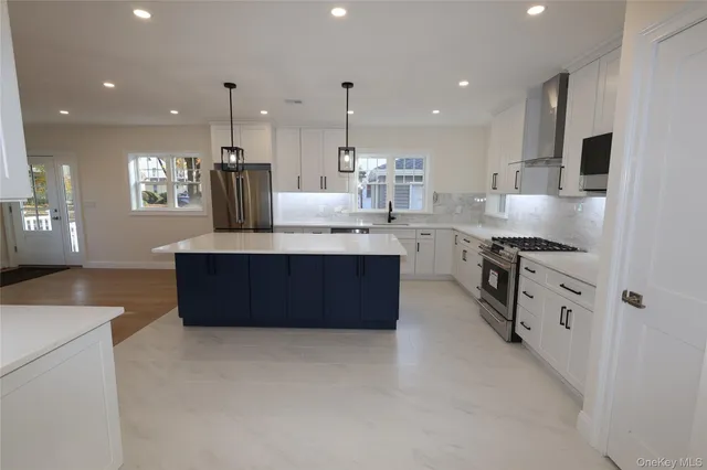 a large kitchen with stainless steel appliances kitchen island granite countertop a large counter top and a stove top oven