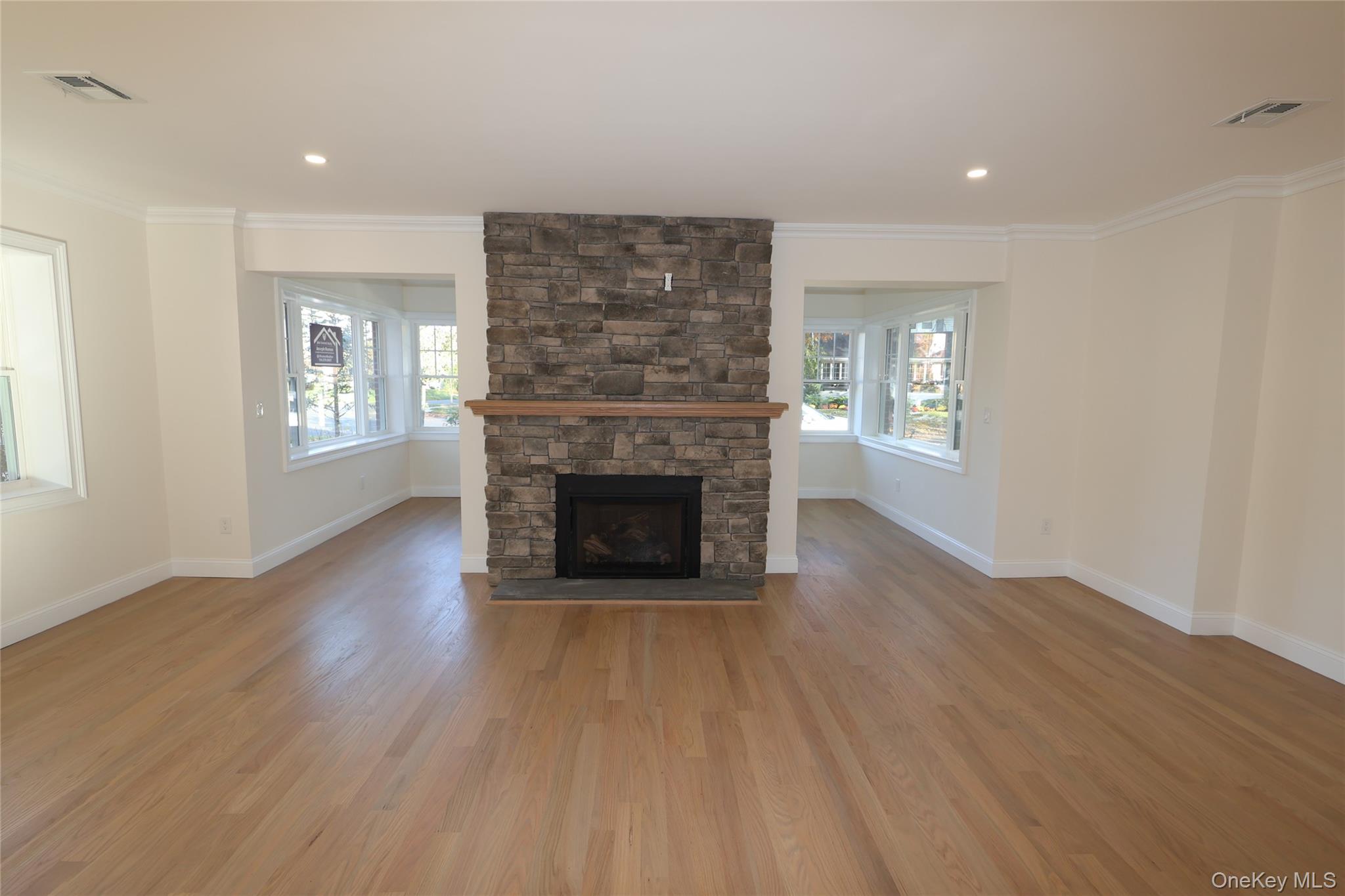 78 Ontario Road Floral Park, NY 11001 - Photo 10 of 33 Unfurnished living room with a fireplace, crown molding, light wood-style floors, and recessed lighting