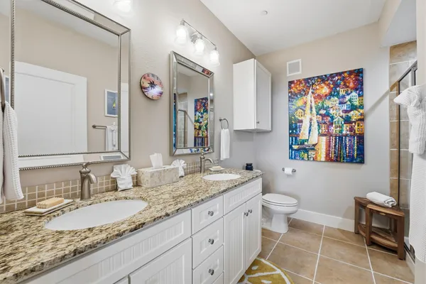 a bathroom with a granite countertop sink mirror vanity and toilet