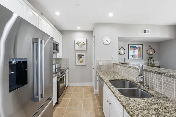 a kitchen with granite countertop a refrigerator and a sink