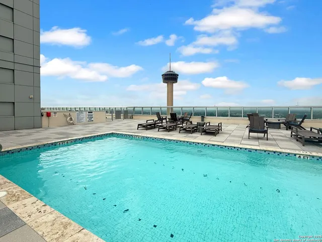 a view of a swimming pool with lawn chairs