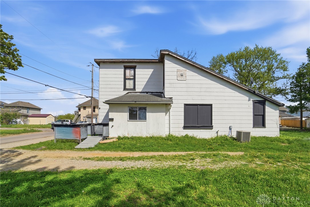 517 Broadway Street, Unit 515 Springfield, OH 45504 - Photo 27 of 29 This residence features white siding and a unique roofline, set on a grassy lot under a clear sky.
