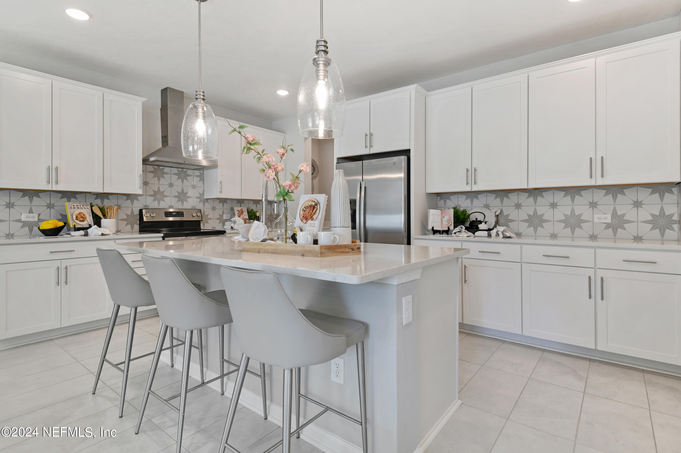 6858 Rhapsody Road Jacksonville, FL 32244 - Photo 4 of 20 a kitchen with stainless steel appliances a sink a stove a refrigerator cabinets and chairs