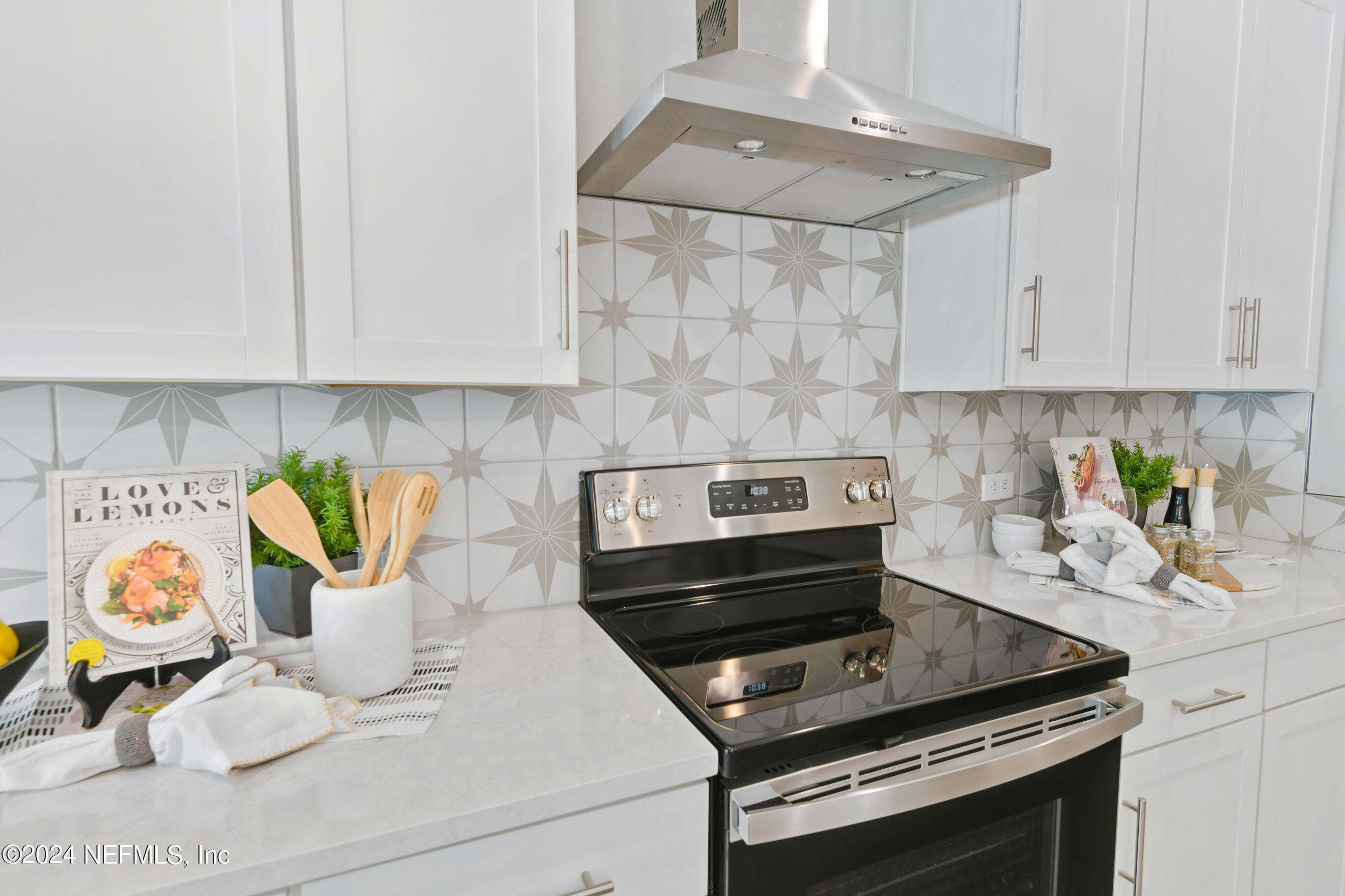 6858 Rhapsody Road Jacksonville, FL 32244 - Photo 6 of 20 a kitchen with a stove and white cabinets