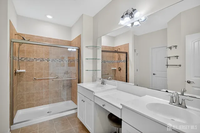 a bathroom with a double vanity sink mirror and shower