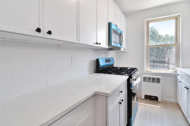 a kitchen with cabinets appliances a sink and a window