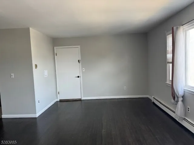an empty room with wooden floor and window