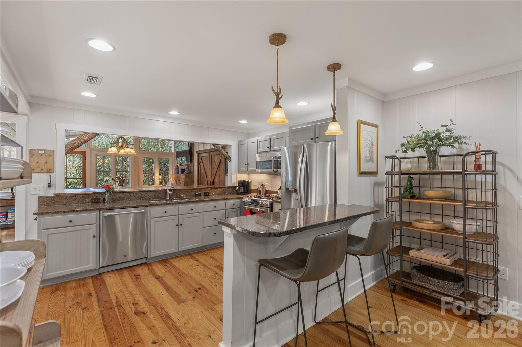 464 Franklin Road Highlands, NC 28741 - Photo 17 of 44 a kitchen with stainless steel appliances kitchen island granite countertop a table chairs and a refrigerator