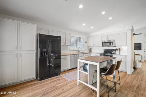 a kitchen with a refrigerator a sink dishwasher and wooden cabinets