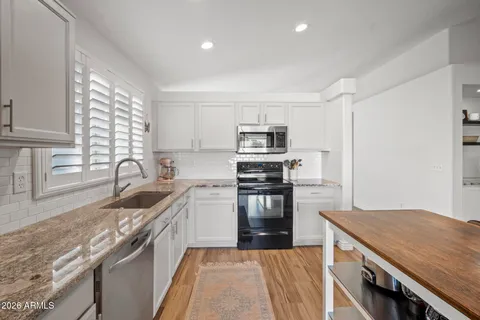 a kitchen with a sink stove top oven and refrigerator