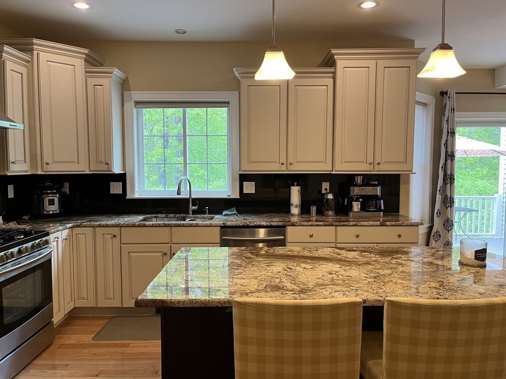 88 Indian Ridge Terrace, Unit 88 Westford, MA 01886 - Photo 12 of 39 a kitchen with kitchen island granite countertop a stove a sink and a granite counter tops