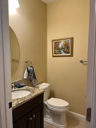 a bathroom with a granite countertop sink and a toilet