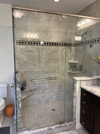 a bathroom with a granite countertop sink a toilet and a mirror