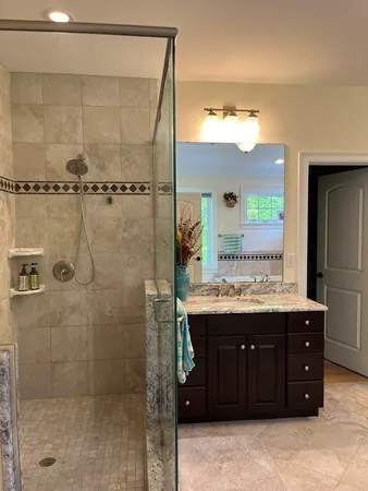 a bathroom with a granite countertop tub and a window