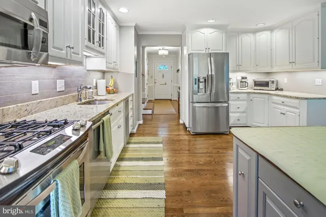 a kitchen with stainless steel appliances granite countertop a refrigerator and a sink