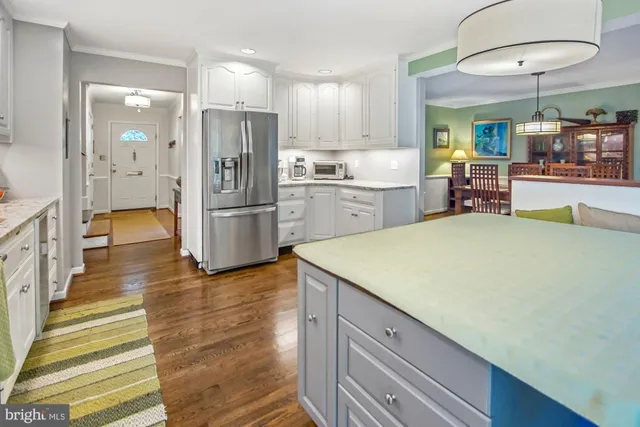 a kitchen that has a lot of cabinets and wooden floor