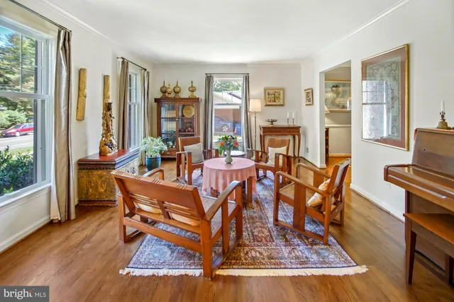 a dining room with furniture a flat screen tv and a floor to ceiling window