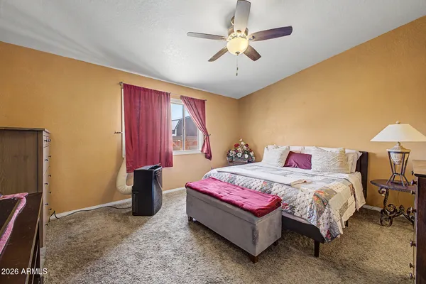 a bedroom with a bed chandelier and a window