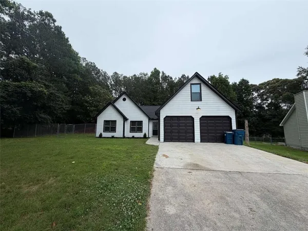 a front view of a house with a yard and trees