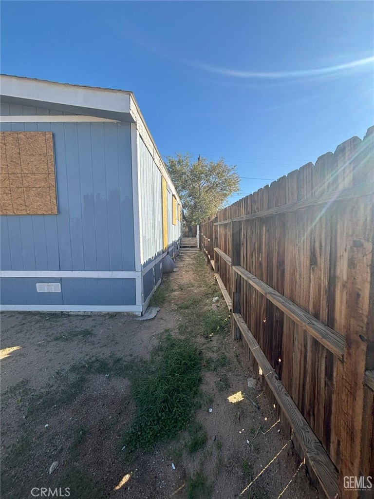 1405 West St George Avenue Ridgecrest, CA 93555 - Photo 5 of 27 a view of a pathway of a house with wooden floor and fence