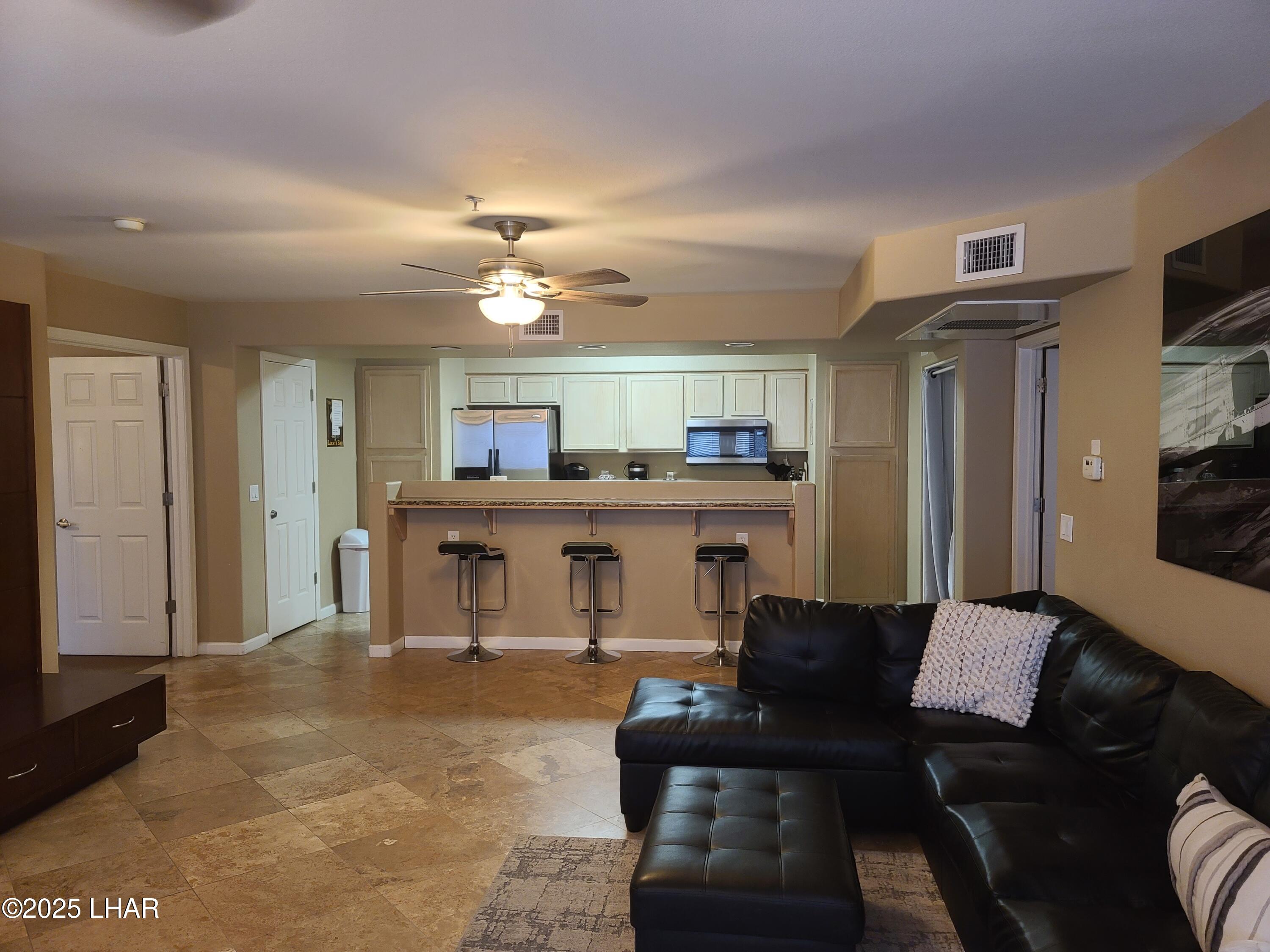 94 London Bridge Road, Unit 108 Lake Havasu City, AZ 86403 - Photo 15 of 38 a living room with stainless steel appliances kitchen island granite countertop furniture and a large window