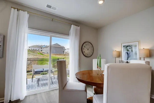 a living room with furniture a dining table and a clock