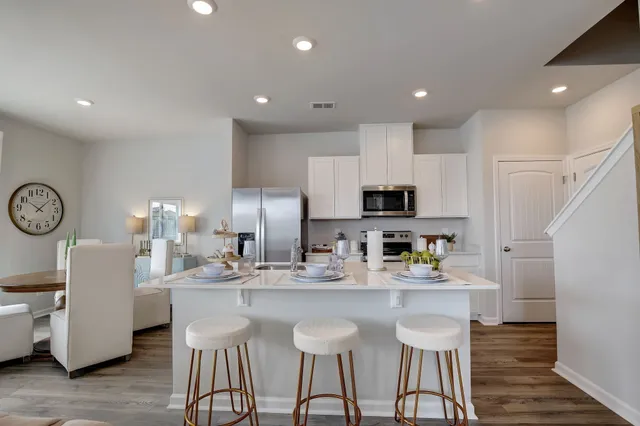 a kitchen with kitchen island granite countertop a sink and a refrigerator