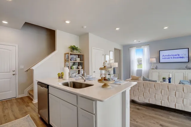 a kitchen with stainless steel appliances kitchen island granite countertop a sink and chairs