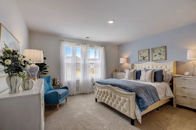 a spacious bedroom with a bed and the table