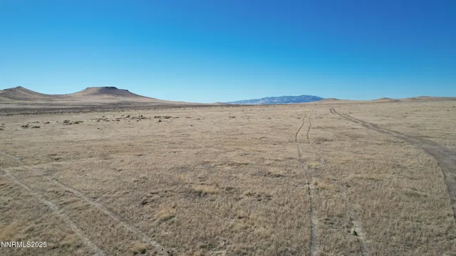 a view of a dry yard with mountains in the background