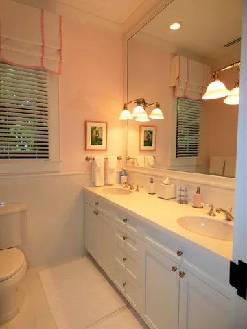 a bathroom with a double vanity sink mirror and toilet