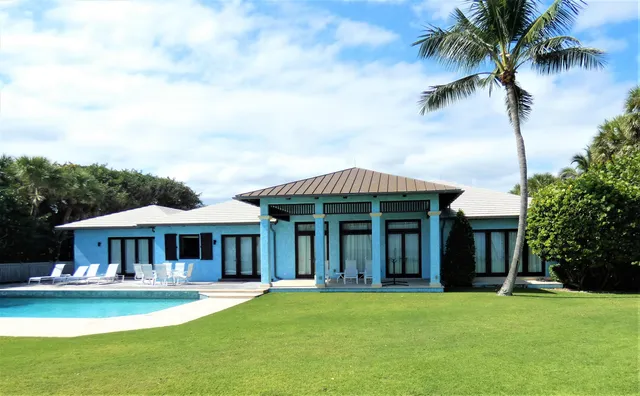 a front view of a house with swimming pool having outdoor seating
