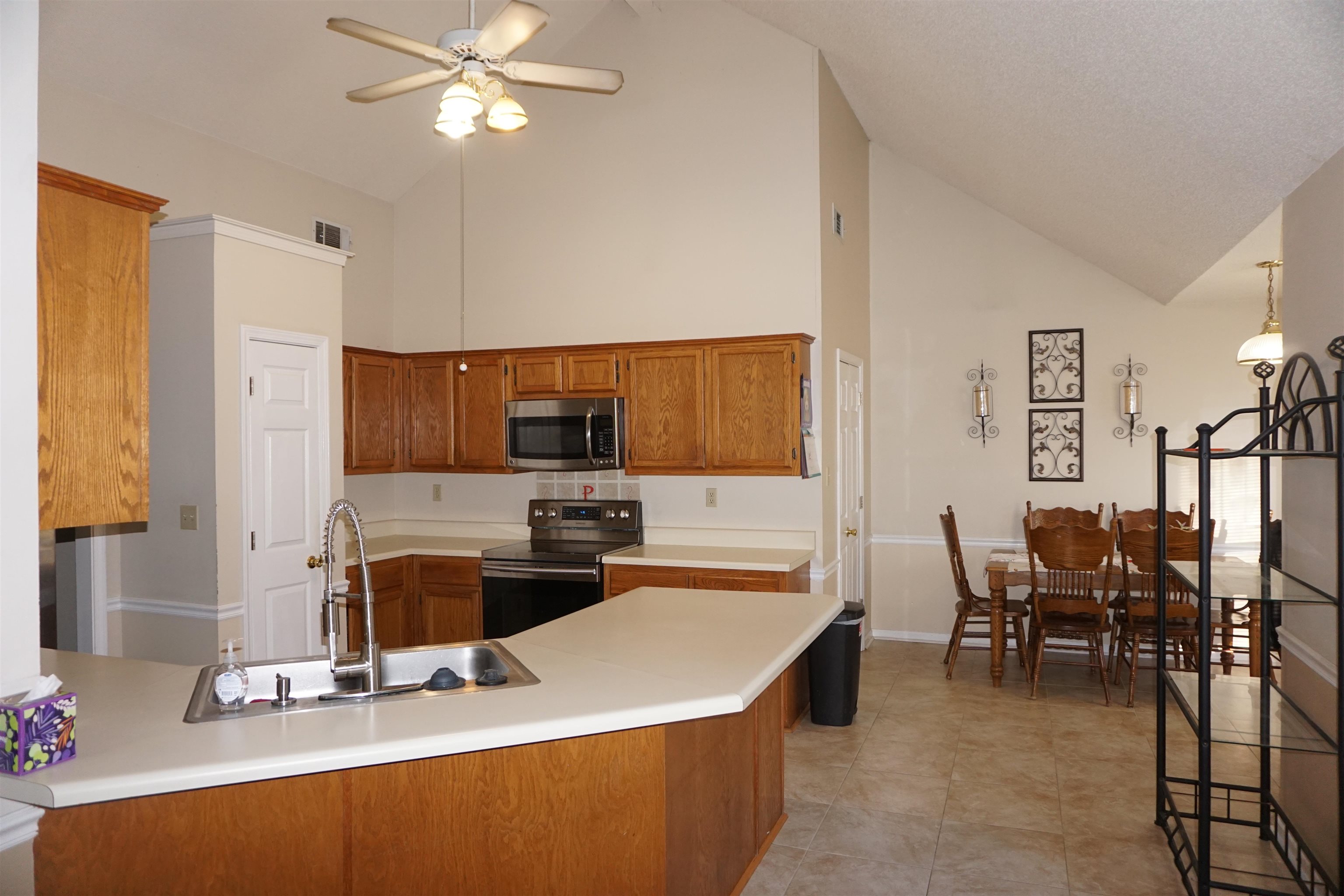 6835 Andrews Road Bartlett, TN 38135 - Photo 3 of 12 Kitchen with sink, ceiling fan, high vaulted ceiling, stainless steel appliances, and kitchen peninsula