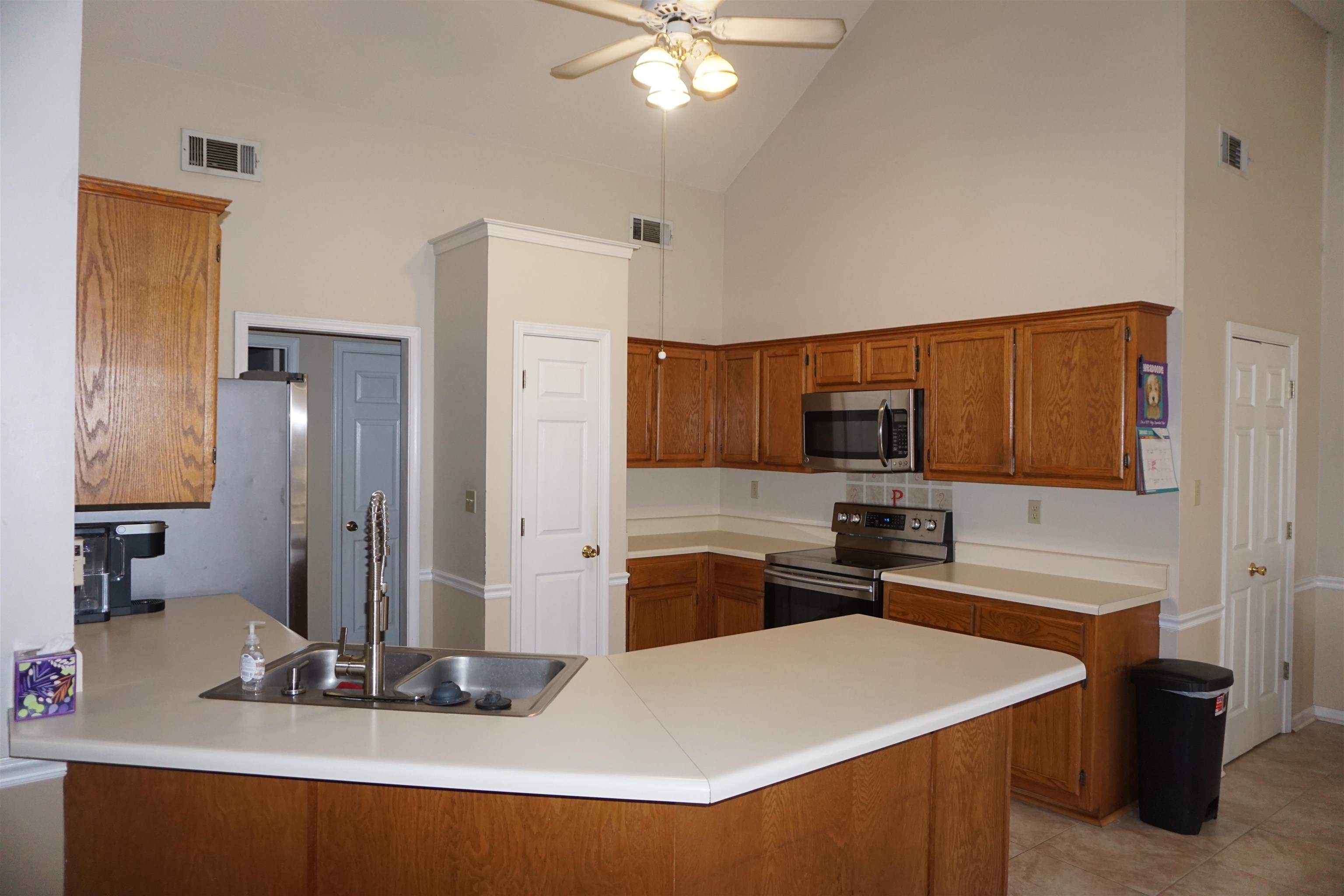 6835 Andrews Road Bartlett, TN 38135 - Photo 4 of 12 Kitchen featuring sink, ceiling fan, high vaulted ceiling, stainless steel appliances, and kitchen peninsula