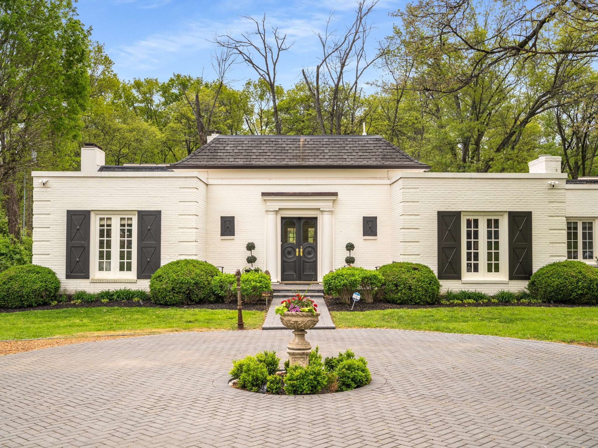 a front view of a house with garden and yellow lighting