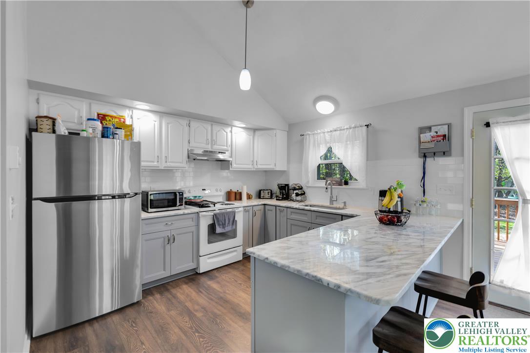 107 Shenkel Road Effort, PA 18330 - Photo 15 of 44 a kitchen with a refrigerator a stove a sink a dining table and chairs