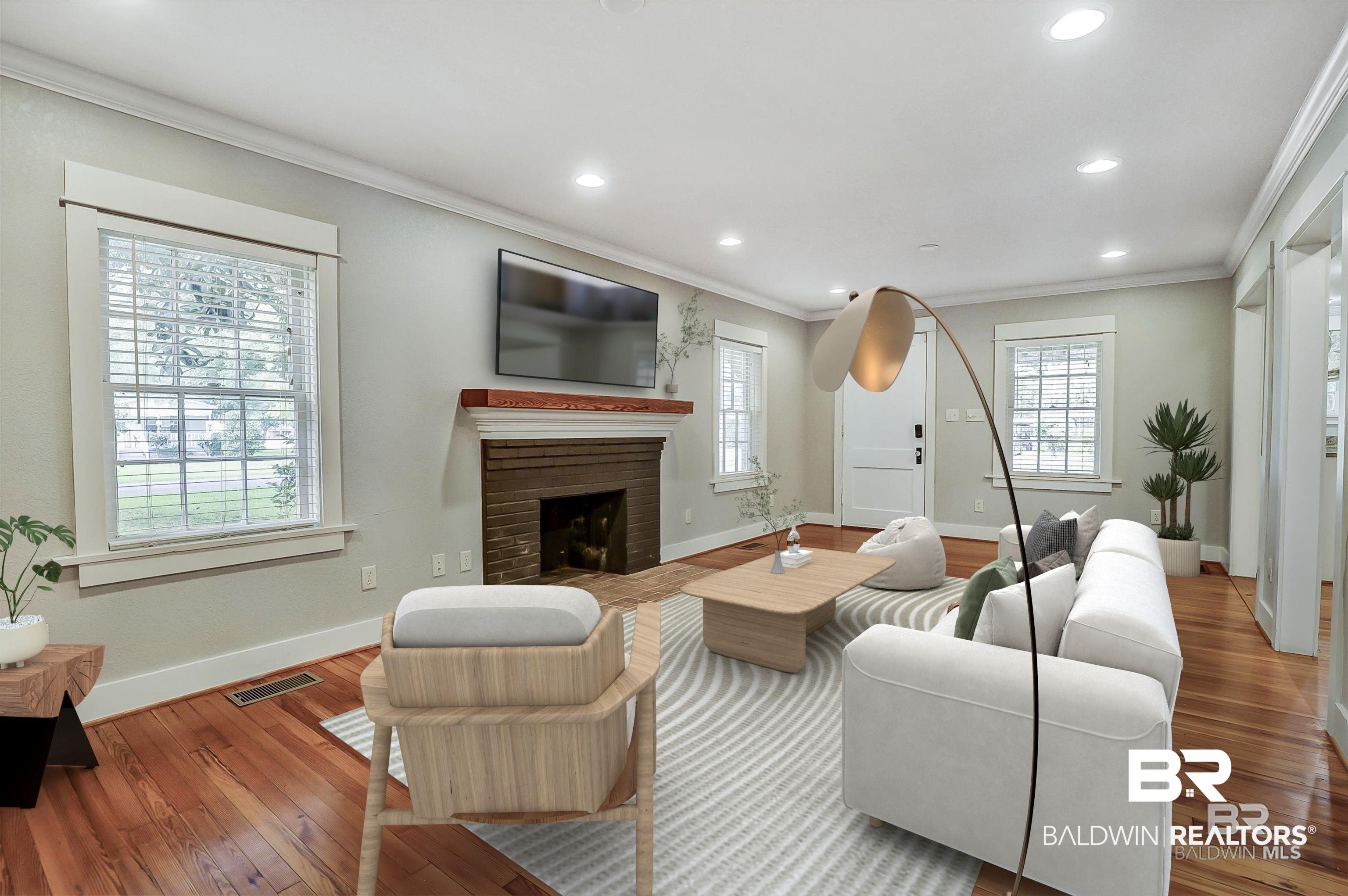 2079 Alabama Street Loxley, AL 36551 - Photo 7 of 42 Living room featuring ornamental molding, a brick fireplace, and wood-type flooring