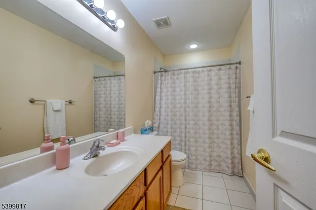 a bedroom with a bed chandelier and a window