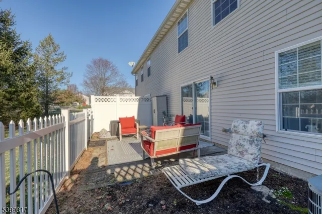 a view of a house with a small yard and a large tree