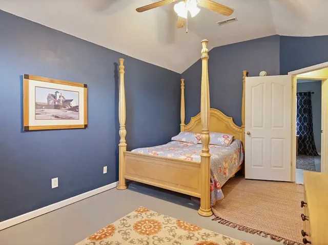 a bedroom with a bed and a painting on the wall