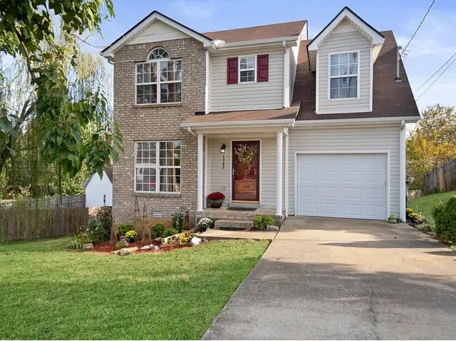 a front view of a house with a yard and garage