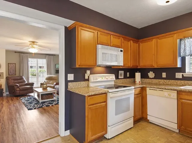 a kitchen with a stove a sink and white cabinets