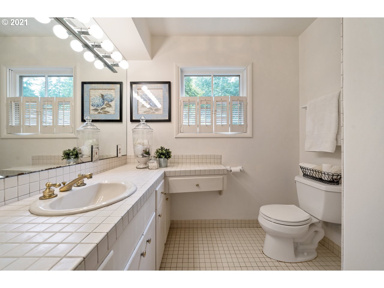 3939 Southwest Altadena Avenue Portland, OR 97239 - Photo 16 of 31 a bathroom with a granite countertop sink a toilet a mirror and a window