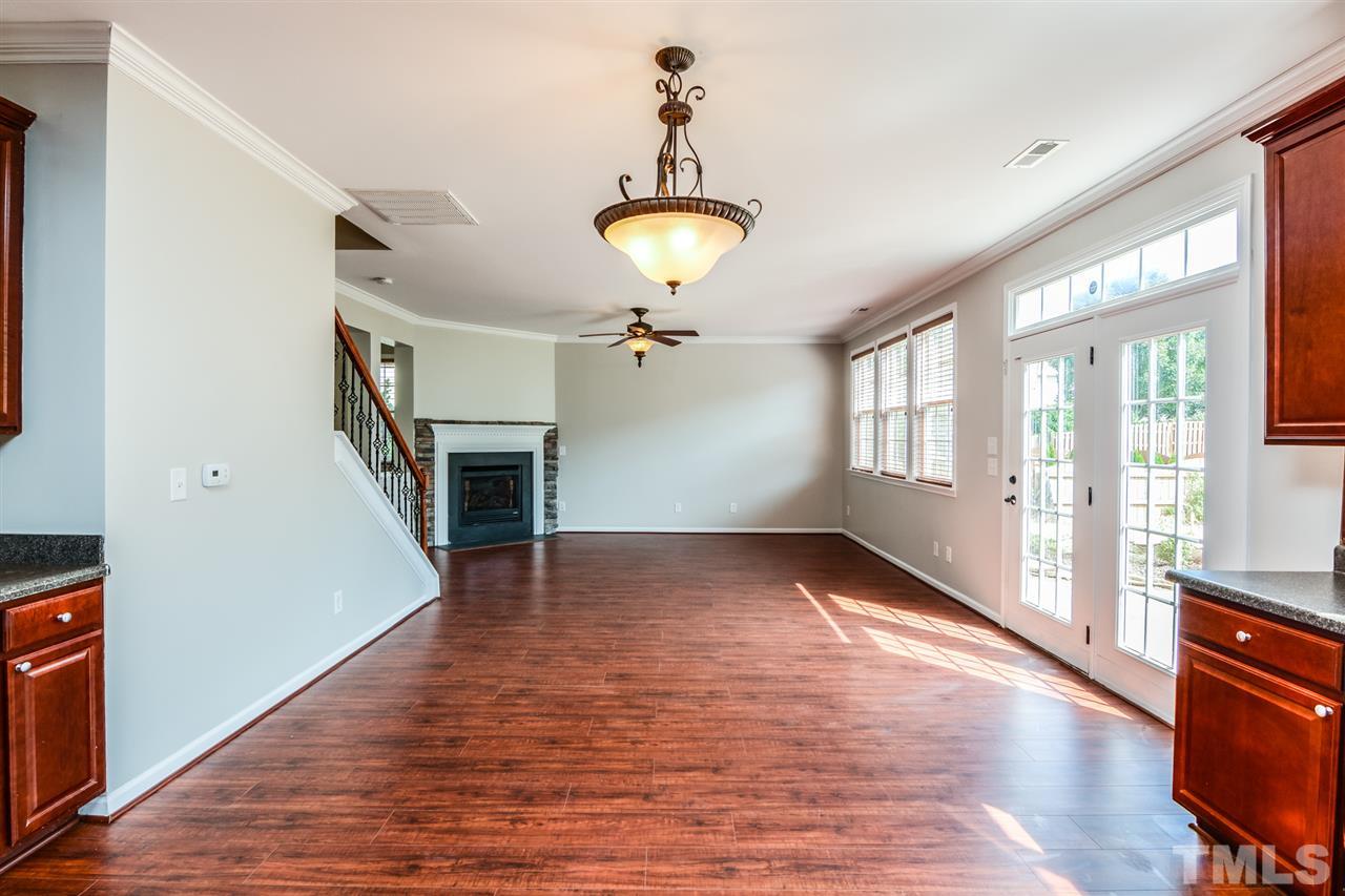 136 Ryder Cup Circle Raleigh, NC 27603 - Photo 4 of 17 a view of an empty room with wooden floor fireplace and a window