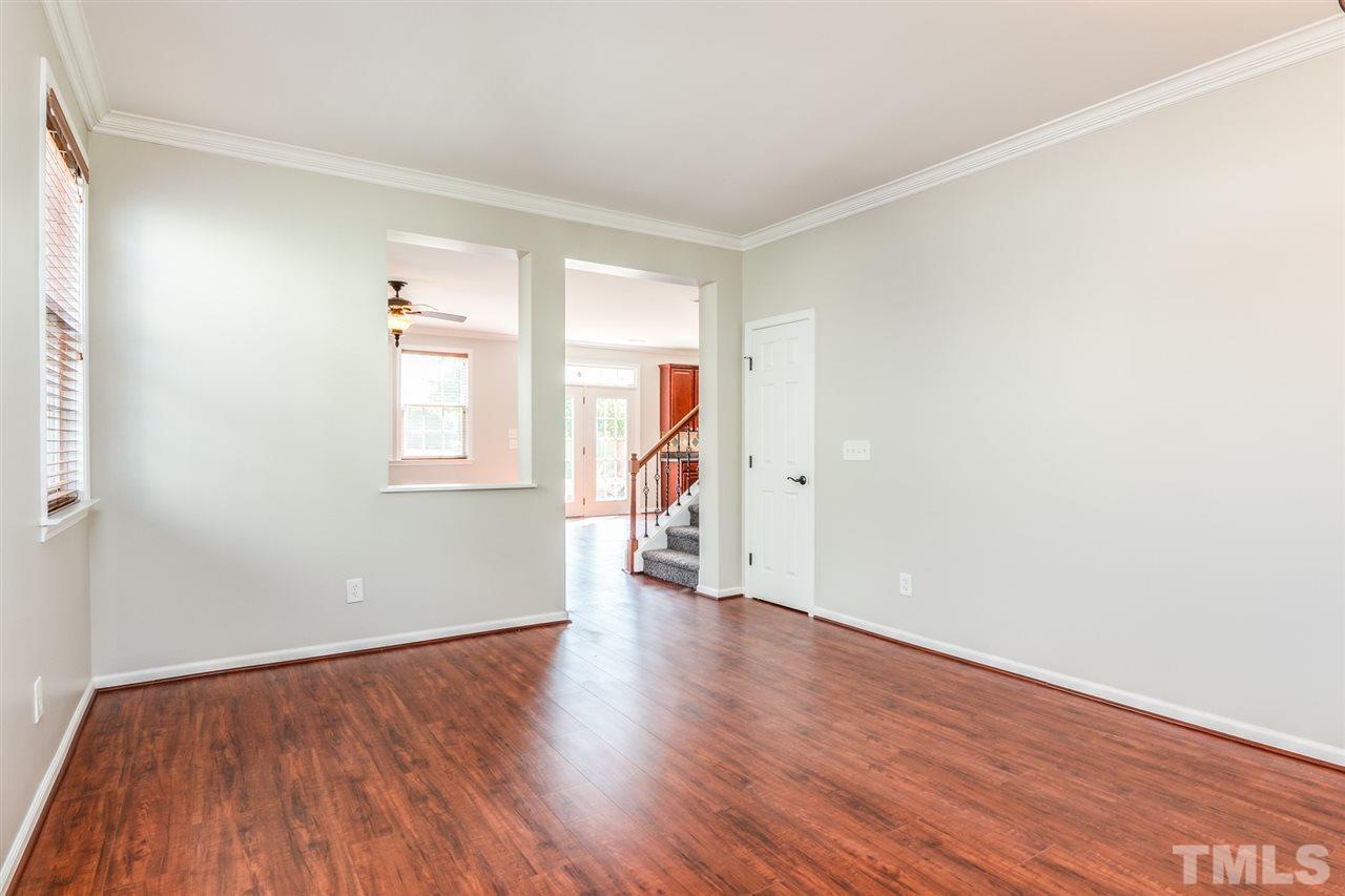 136 Ryder Cup Circle Raleigh, NC 27603 - Photo 6 of 17 an empty room with wooden floor and a window