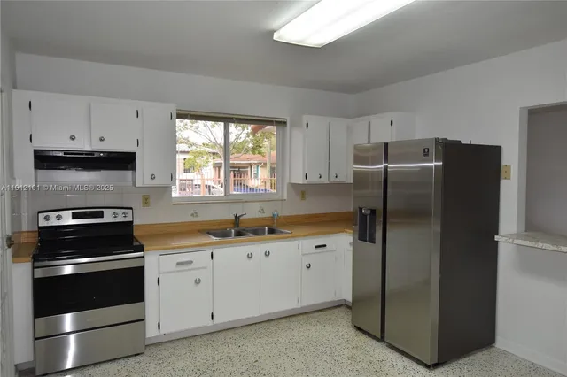 a kitchen with stainless steel appliances a refrigerator sink and cabinets